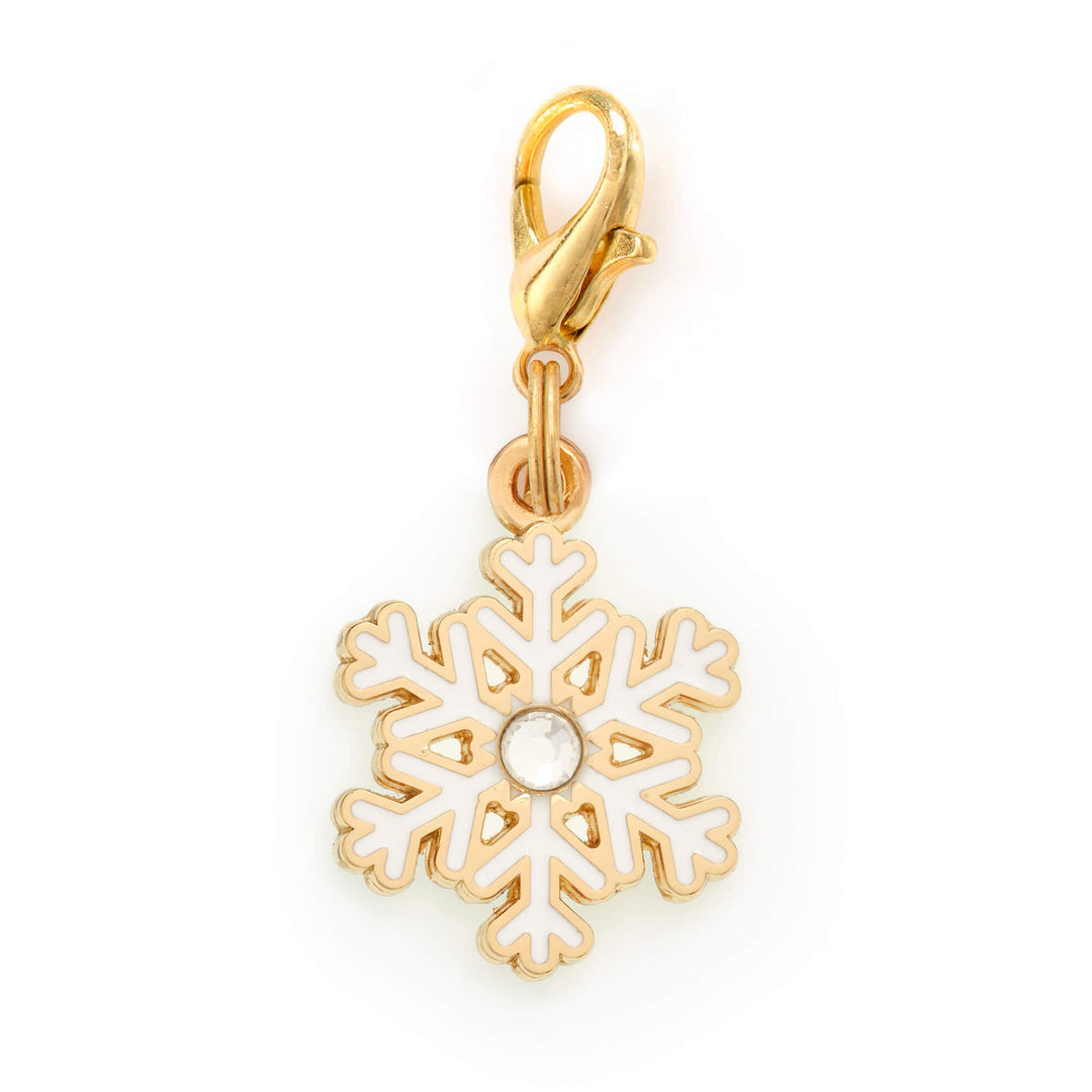 White enamel snowflake dog collar charm with a crystal center and gold outline, on a lobster clasp