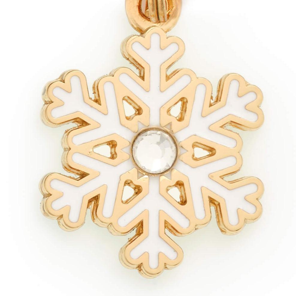 Close-up of the snowflake charm showing the round crystal center and gold edges