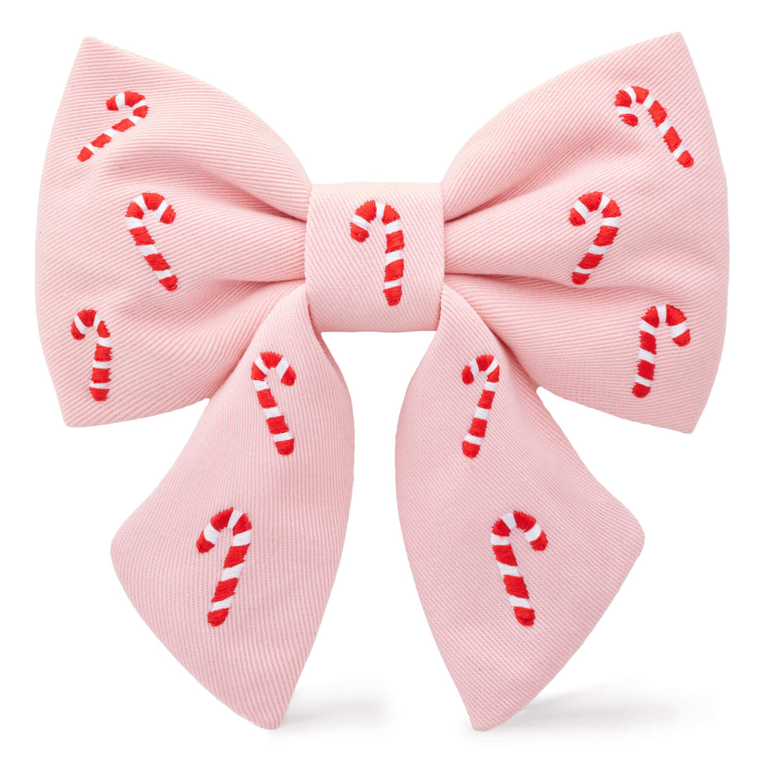 Blush pink sailor dog bow embroidered with red and white candy canes, front view on white