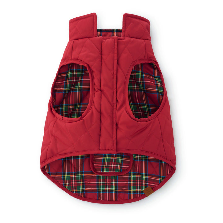 Front of the reversible dog jacket with plain red quilting outside and tartan fabric visible inside.