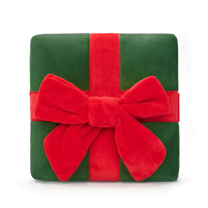 Green plush Christmas present dog toy tied with a red ribbon and large red bow on white