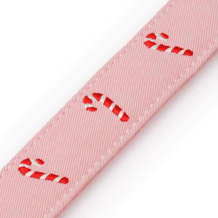 Close-up of embroidered candy canes running along the blush pink collar