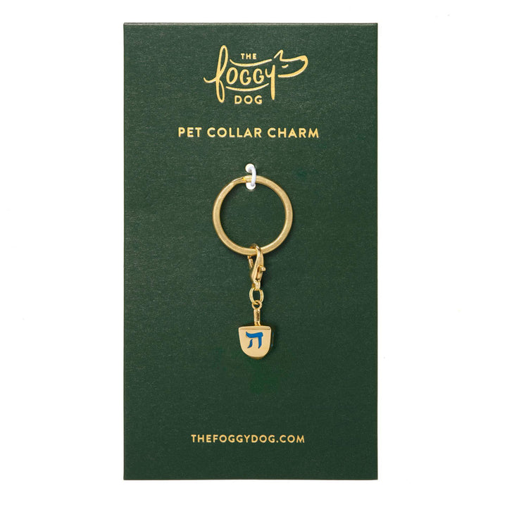 Gold dreidel charm on its green The Foggy Dog pet collar charm card