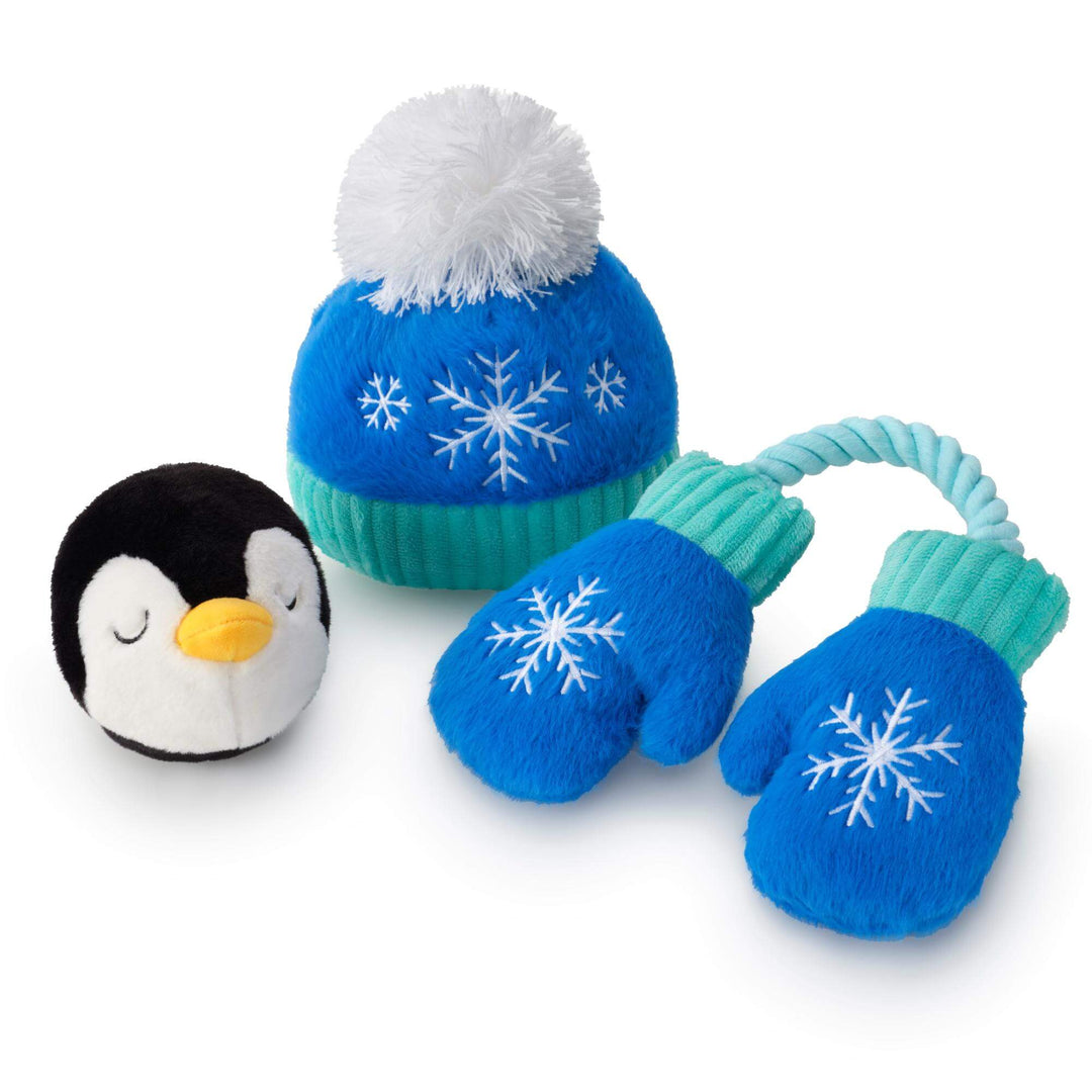 Penguin bounce toy beside the blue snowflake hat and rope mittens dog toy on white