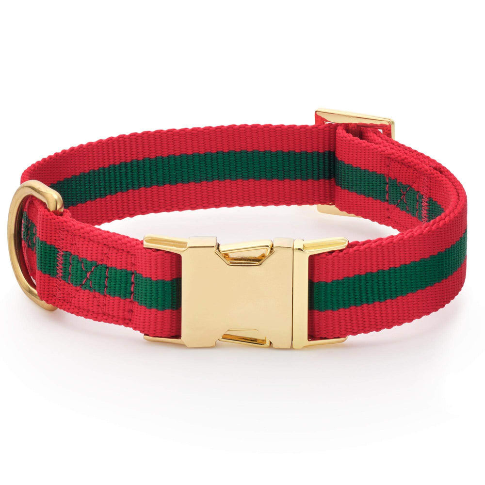 Noel striped dog collar rolled into a circle, showing its red edges, green center stripe, and gold buckle.