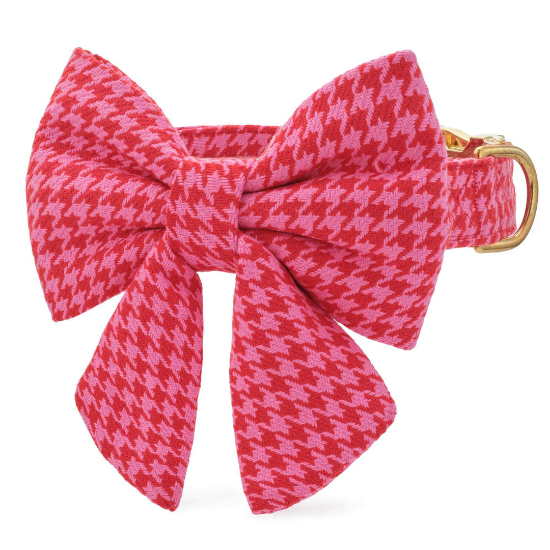 Pink and red houndstooth dog collar with a large matching sailor bow and gold D-ring on white.