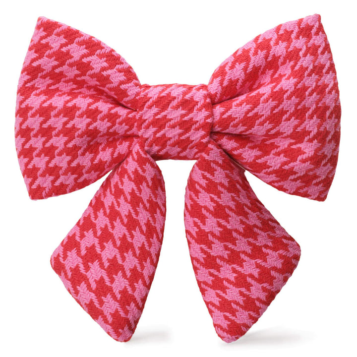 Pink and red houndstooth sailor dog bow with two tapered tails on white.