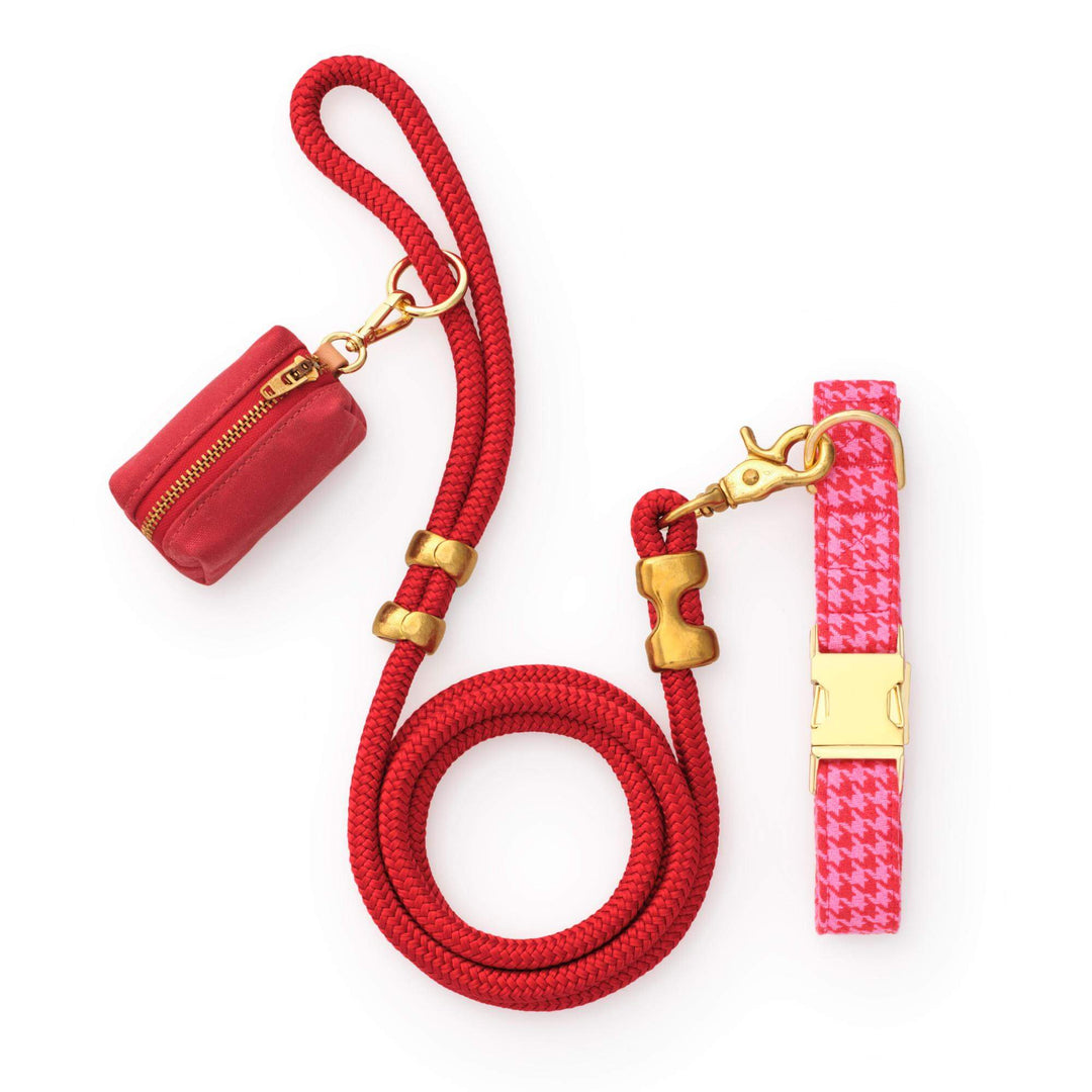 Red rope leash, red waxed canvas bag holder, and pink and red houndstooth collar on white