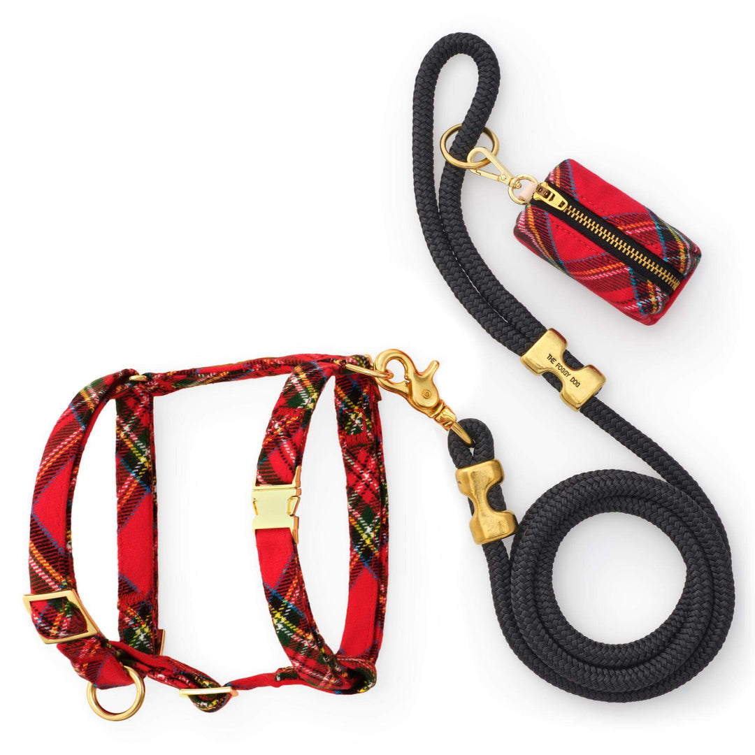Red tartan dog harness with gold hardware, black coiled rope leash, and matching tartan zippered bag holder on white.