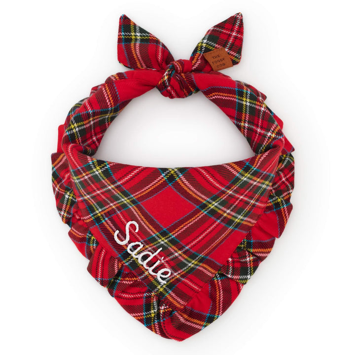 Tartan ruffled dog bandana tied in a knot and personalized with white Sadie embroidery.