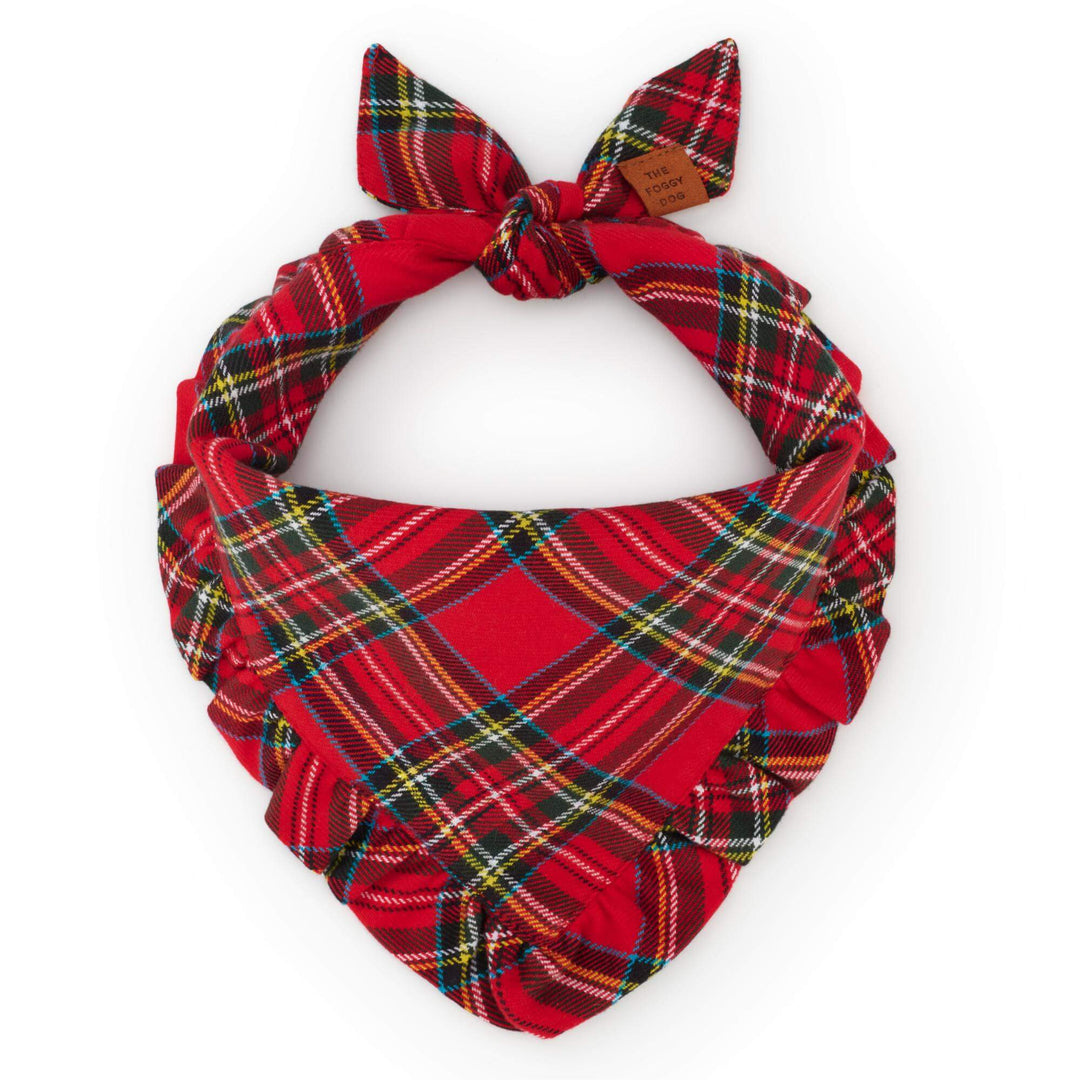 Red tartan dog bandana with a matching ruffled edge, tied into a circle on white.