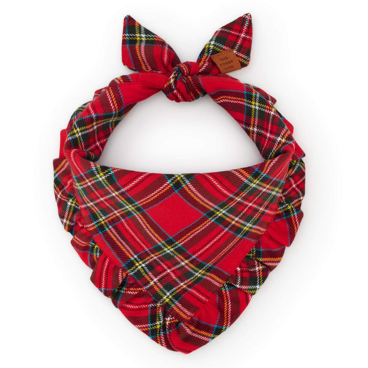 Red tartan dog bandana with a matching ruffled edge, tied into a circle on white.