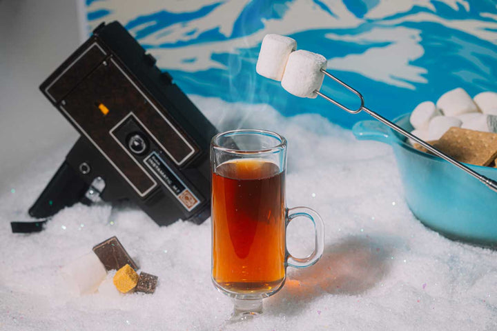 Cozy rum hot toddy on a winter table with blankets