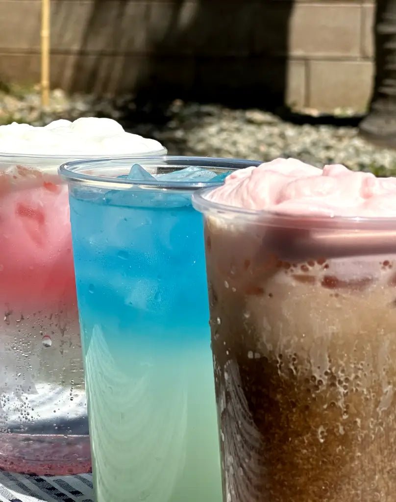 Glasses of red and blue craft soda made with flavored mixer cubes on a party table