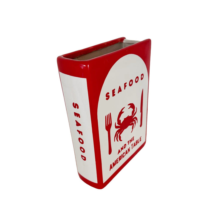 Rectangular container with red and white design featuring a crab and text on a white background