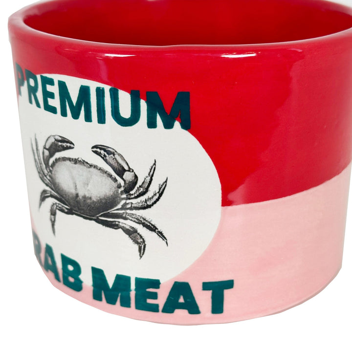 Close-up of the glossy crab illustration and Crab Meat lettering on the red and pink ceramic can vase