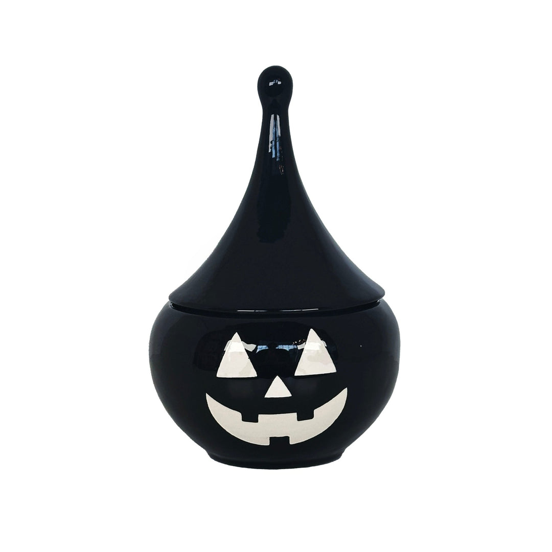 Black ceramic jar with a jack-o'-lantern face on a white background