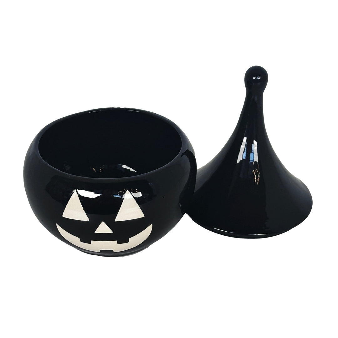 Black ceramic pumpkin with a face design on a white background