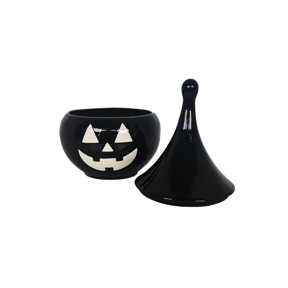 Black ceramic bowl with a jack-o'-lantern face design on a white background