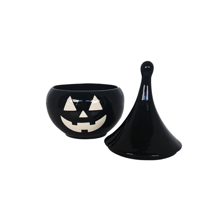 Black ceramic bowl with a jack-o'-lantern face design on a white background
