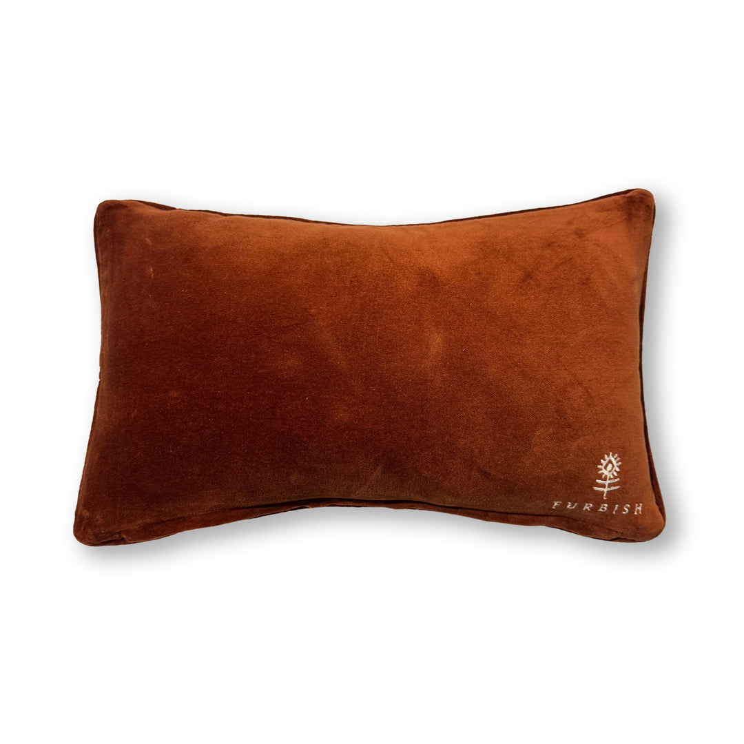 Rust brown velvet back of a needlepoint throw pillow with an embroidered flower logo for home decor