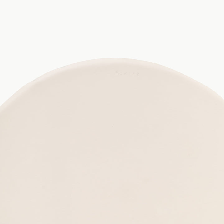 Cream round padded play mat, close-up of the wipeable vegan leather surface.