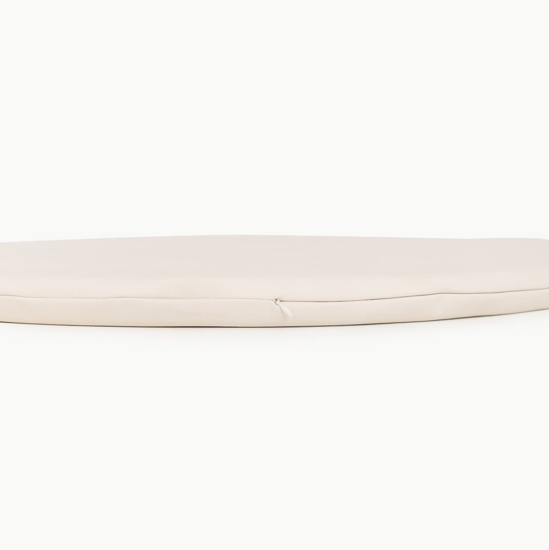 Cream round padded play mat side view showing the cushioned zippered edge.