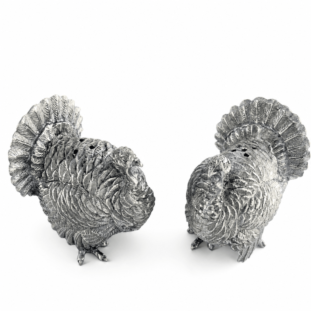 Pewter turkey shakers showing the pour holes on top of each turkey's back