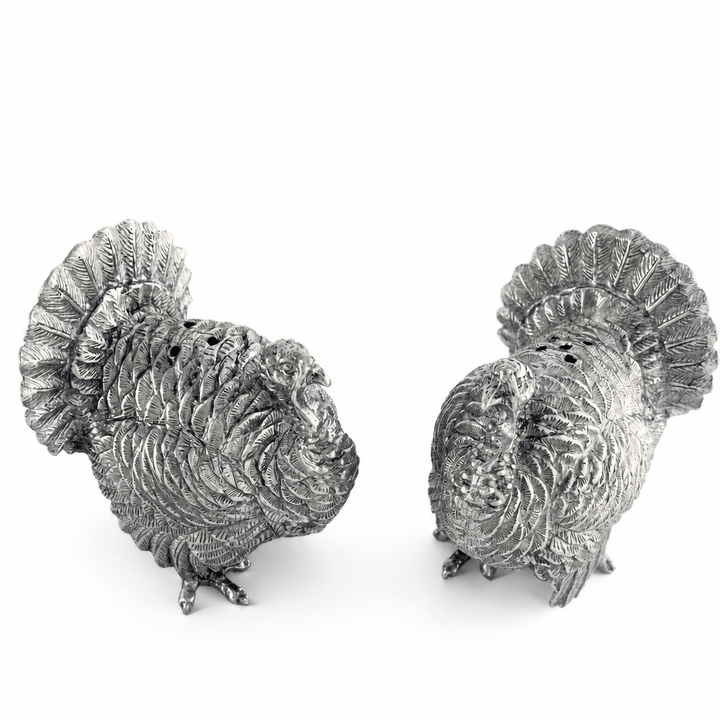 Pewter turkey shakers showing the pour holes on top of each turkey's back