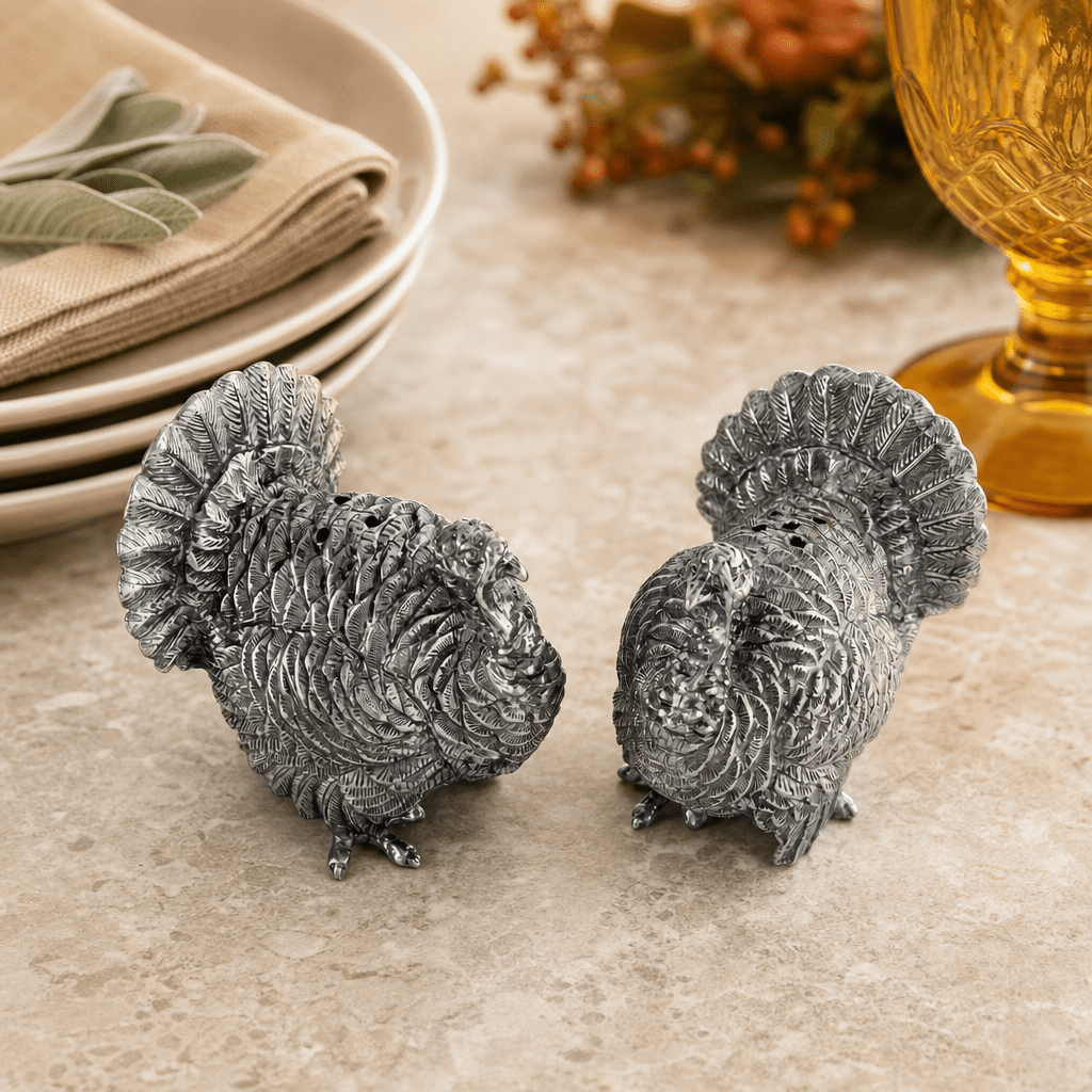 Back view of the pewter turkey shakers showing layered tail feathers, with sage and an amber glass
