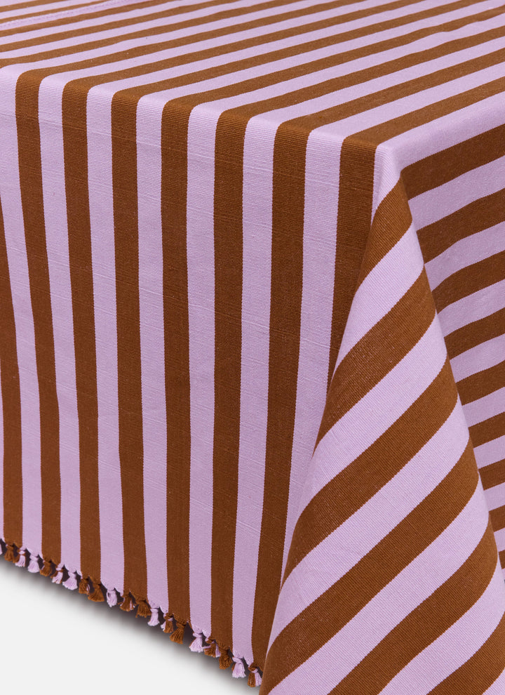 Lilac and nutmeg brown stripe tablecloth in handwoven cotton, draped to show its tasseled edge