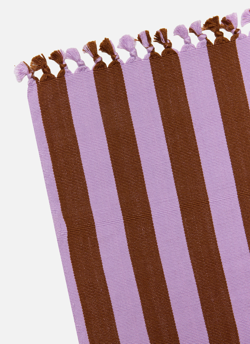 Lilac and nutmeg stripe tablecloth folded lengthwise showing the knotted tassel trim