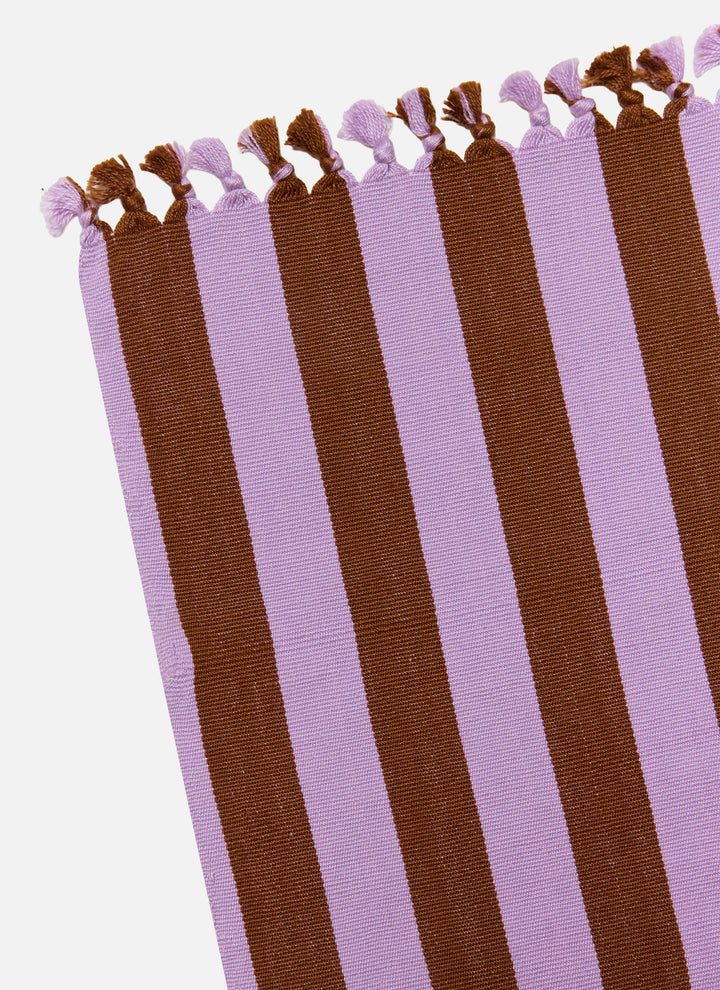 Lilac and nutmeg stripe tablecloth folded lengthwise showing the knotted tassel trim