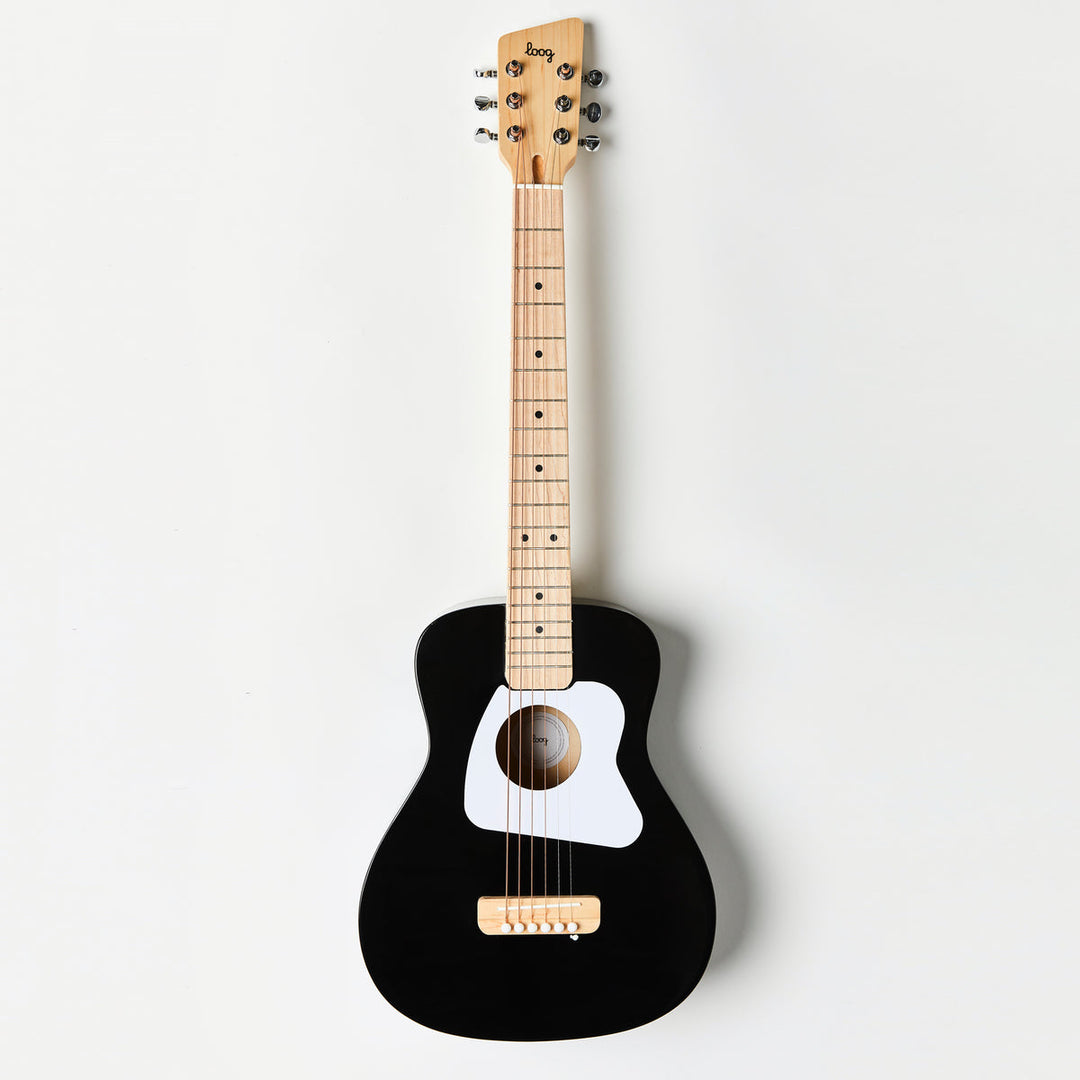 Black acoustic guitar with a white soundhole on a light gray background