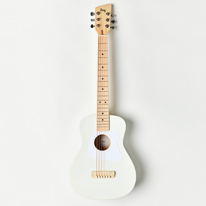 White acoustic guitar with a wooden neck on a light gray background