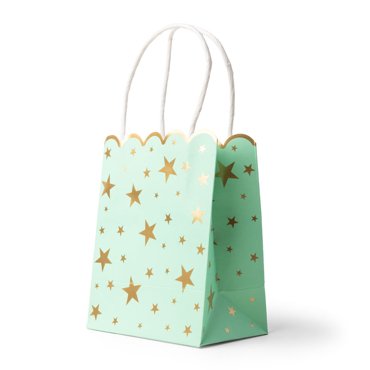 A mint green paper gift bag with a scalloped top edge, decorated with metallic gold stars of various sizes, and finished with white twisted paper handles, shown on a white background.