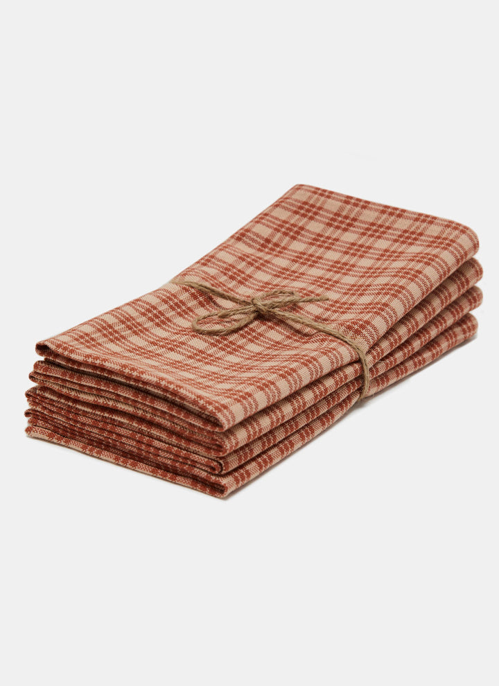 Stack of four Katherine plaid sienna napkins tied with twine on a white background
