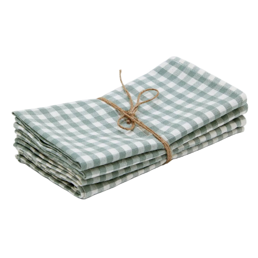 A stack of folded green and white gingham check linen napkins tied with a natural jute twine bow, set against a plain light gray background.