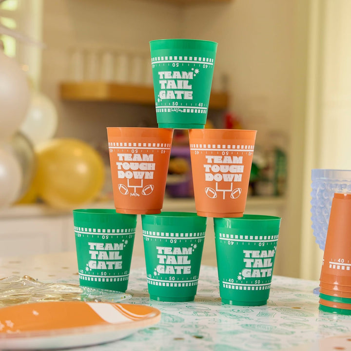 Green and brown football pong cups racked in a pyramid on a party table