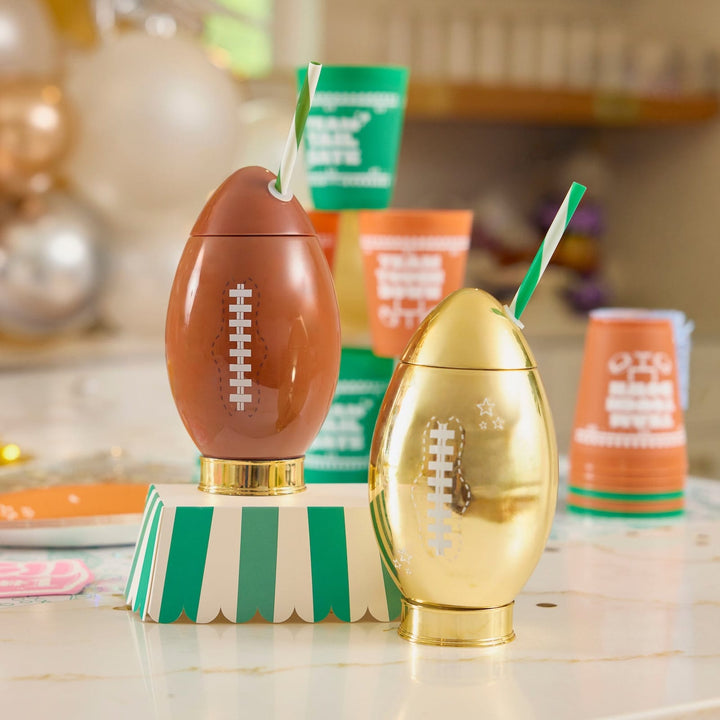 Gold football cup beside a brown football cup and game day cups on a party counter