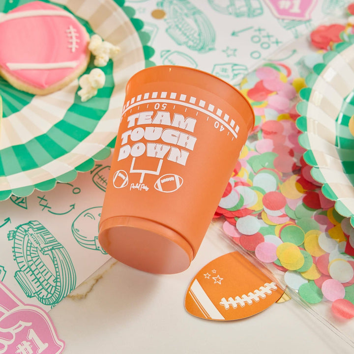 Brown Team Touchdown cup and a football plate on a table with pastel confetti