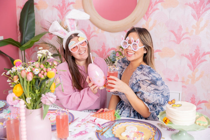 Two friends at an Easter brunch table, one wearing the plush confetti bunny ears