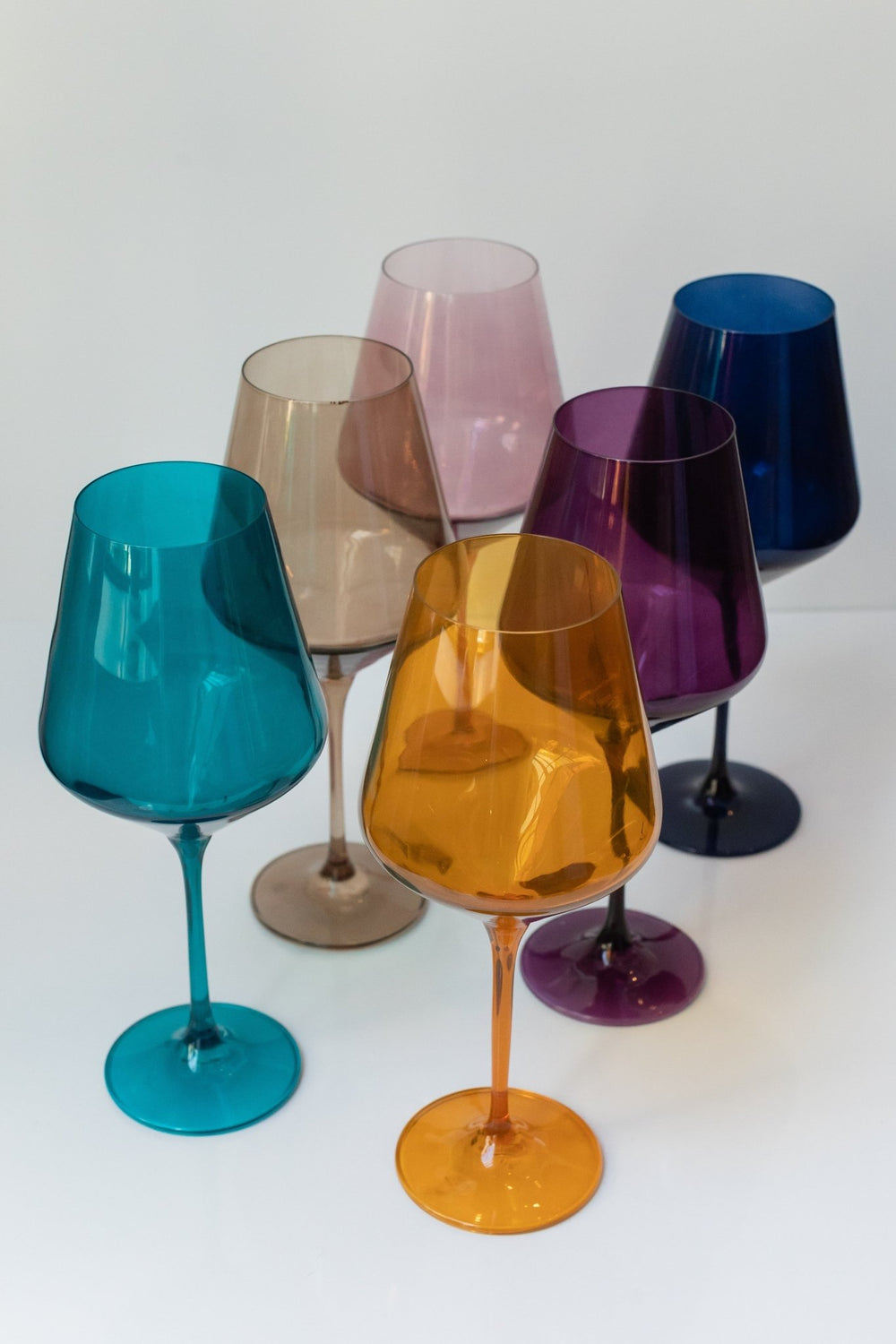Estelle fall mixed colored glass wine glasses clustered together, shown tall in frame, for a celebration table