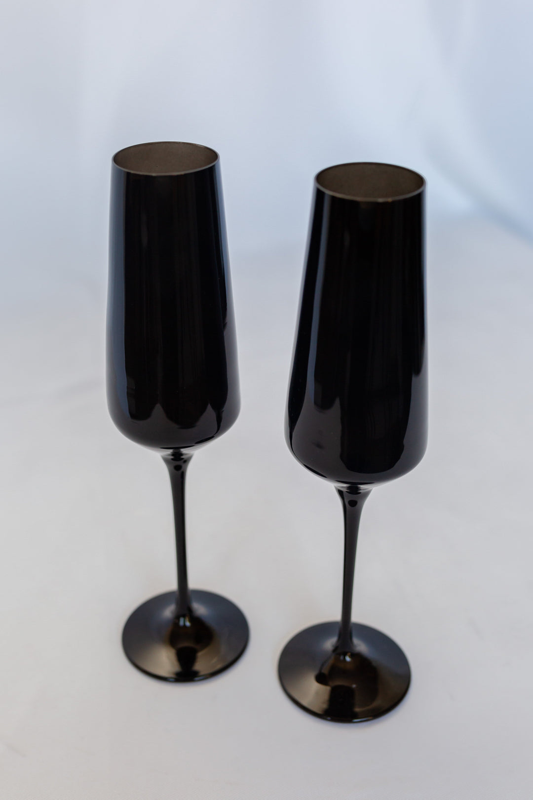Two black champagne flutes on a white background