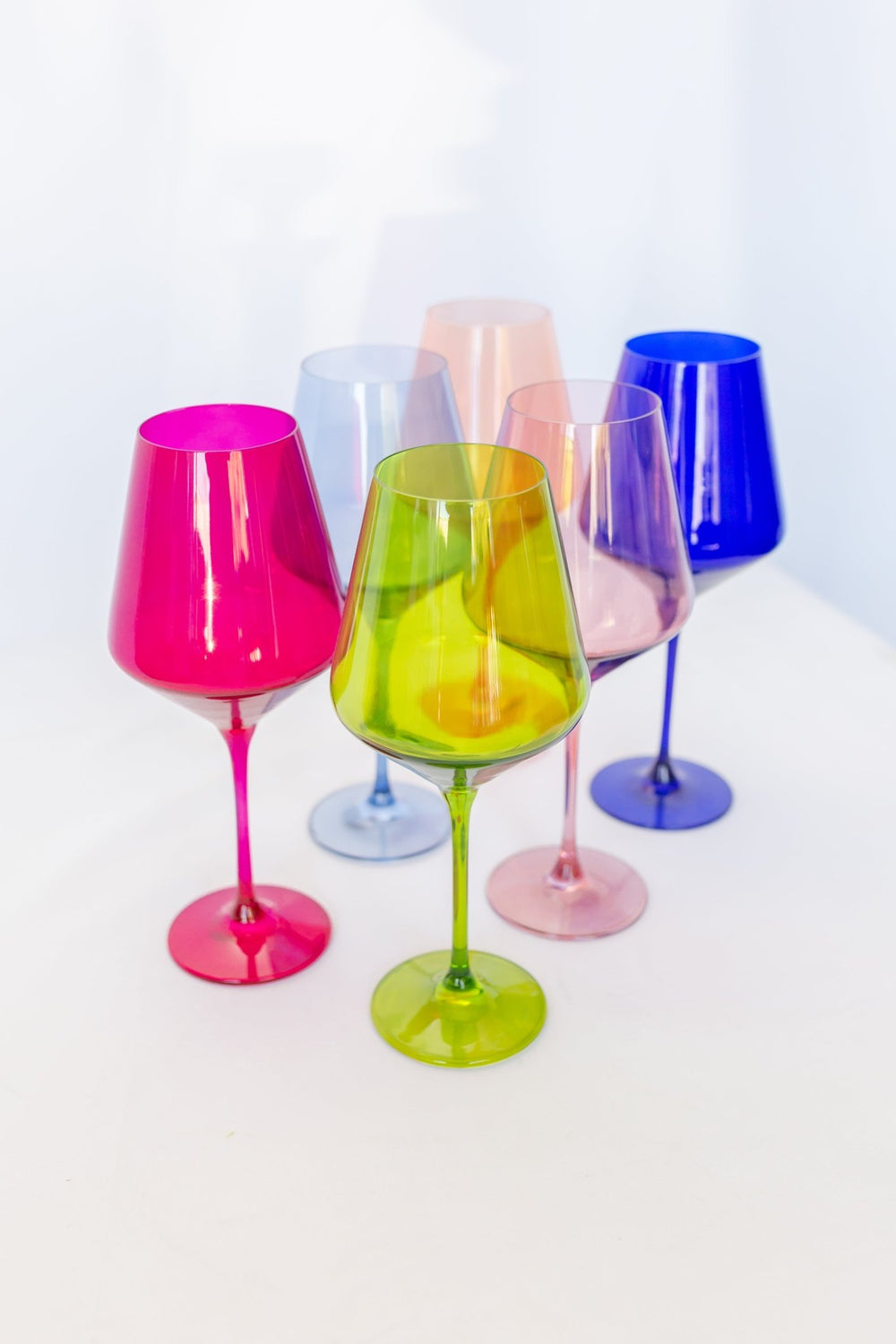Estelle mixed brights colored glass wine glasses clustered together, shown tall in frame, for a celebration table
