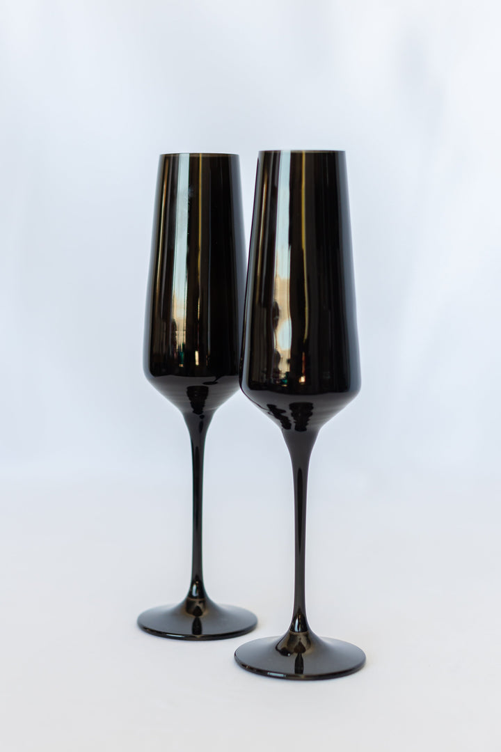 Two black champagne flutes on a white background
