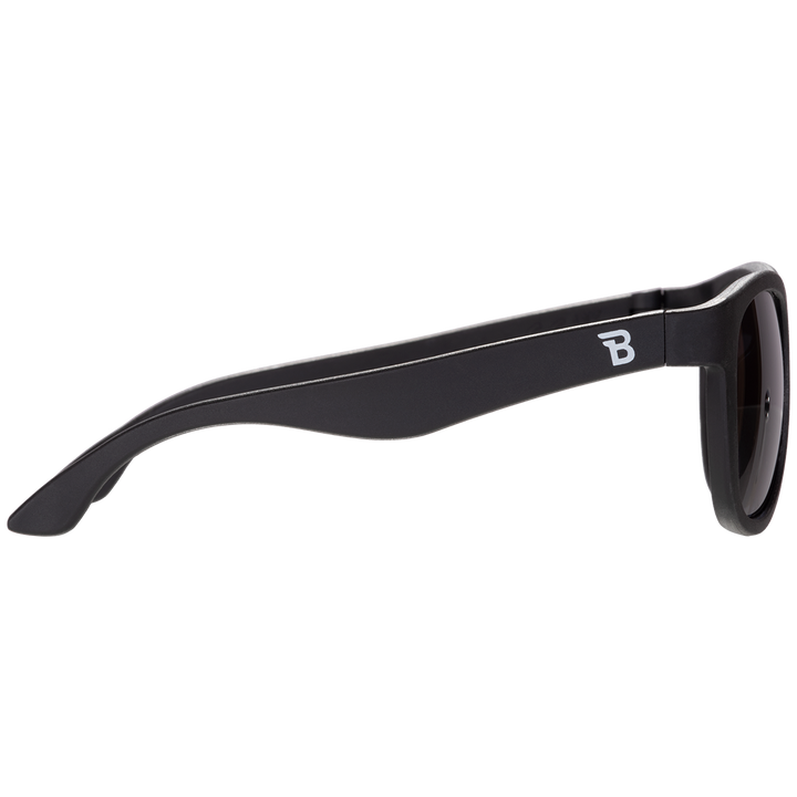 Side profile of black aviator kids sunglasses showing the flexible temple arm and Babiators logo.