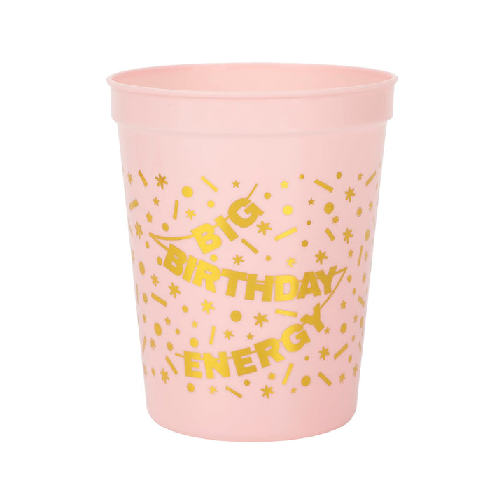 Front of a pink reusable cup with gold Big Birthday Energy lettering and confetti print