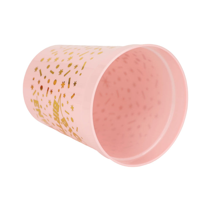 Pink Big Birthday Energy cup tipped on its side to show the gold print inside the rim