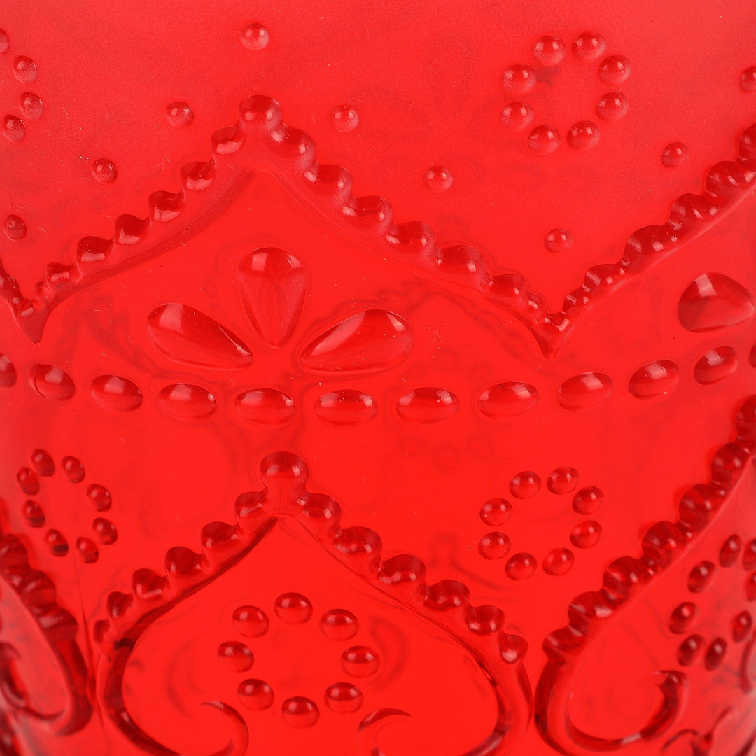 Close-up of the red tumbler's raised scrolls, hearts, and dotted pattern